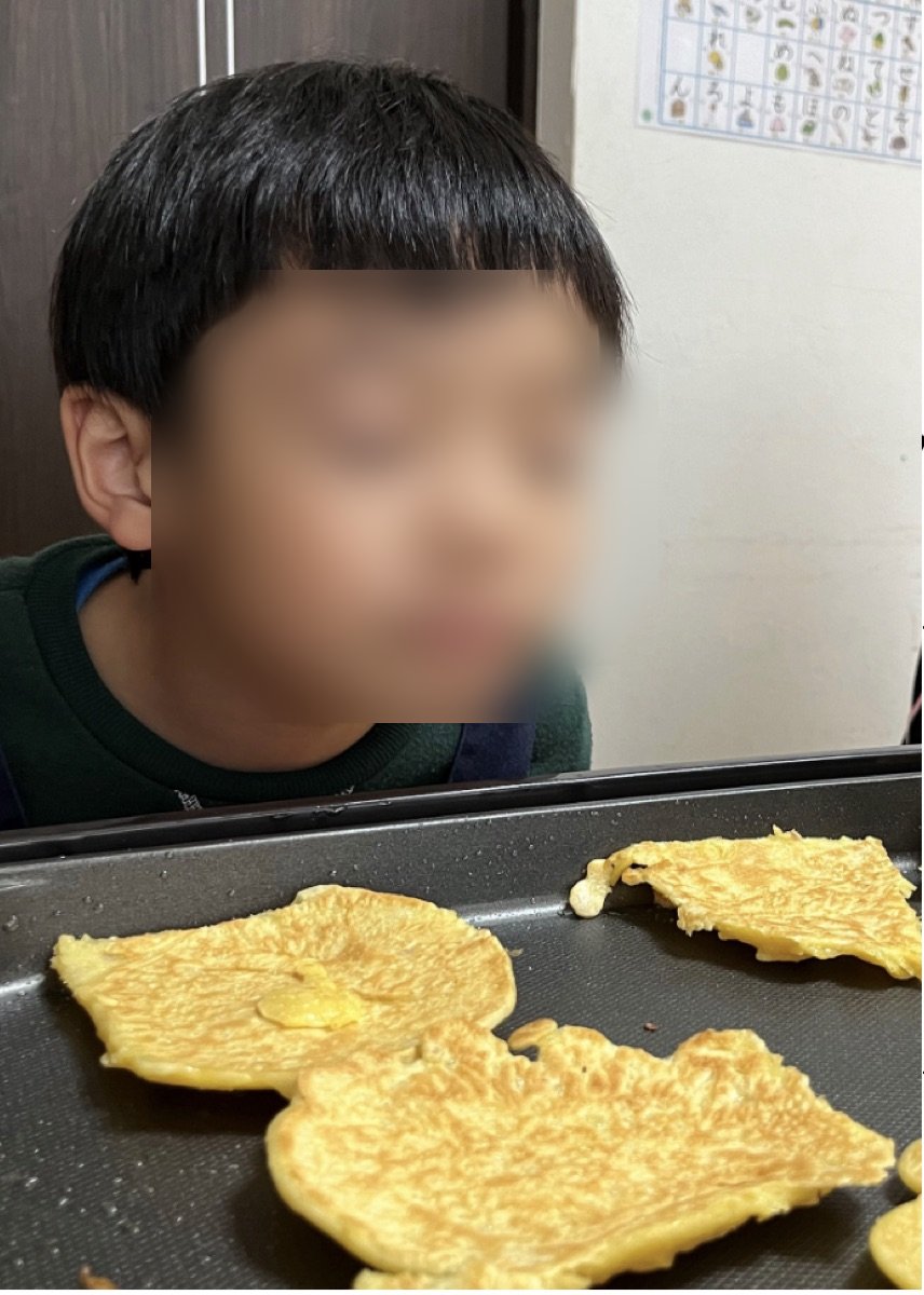 ホットプレートで焼いたおやつを見つめる子ども